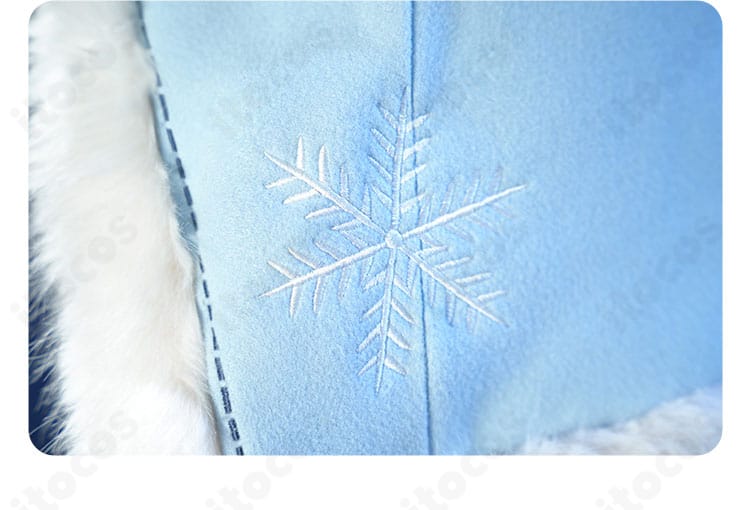 コート裾に施した雪の結晶モチーフの近接。冬らしいアクセントがポイント。