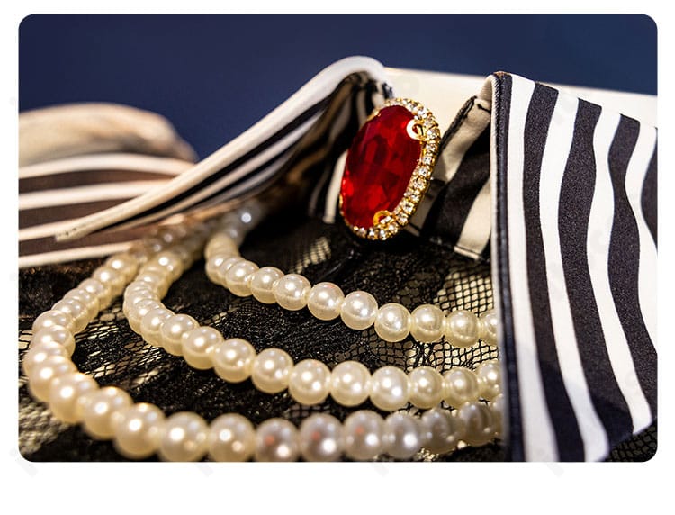 襟元とネックレスのクローズアップ。アモーリスらしい首周りアクセの質感が分かるカット。