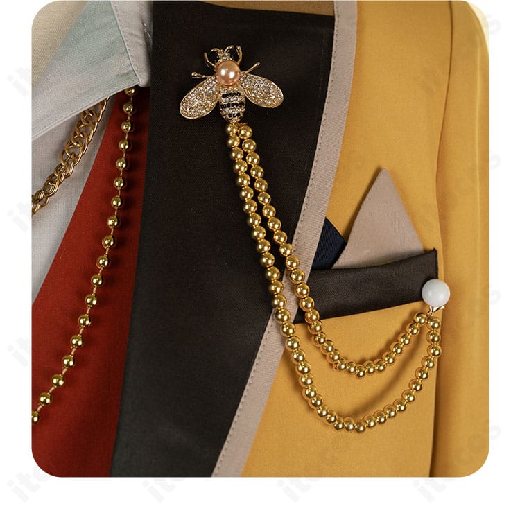 胸元バッジのディテール。メタル調パーツで存在感を出した装飾の接写