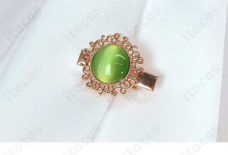 胸元のエンブレム風ディテールのクローズアップ。モチーフの立体感がアクセントになる