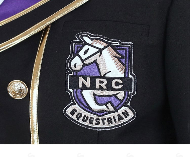 コート胸前の徽章装飾アップ。紋章モチーフの質感と縫製を強調