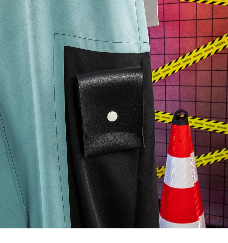 サロペットのポケット装飾。フラップとステッチの構成、収納感を伝えるアップ。