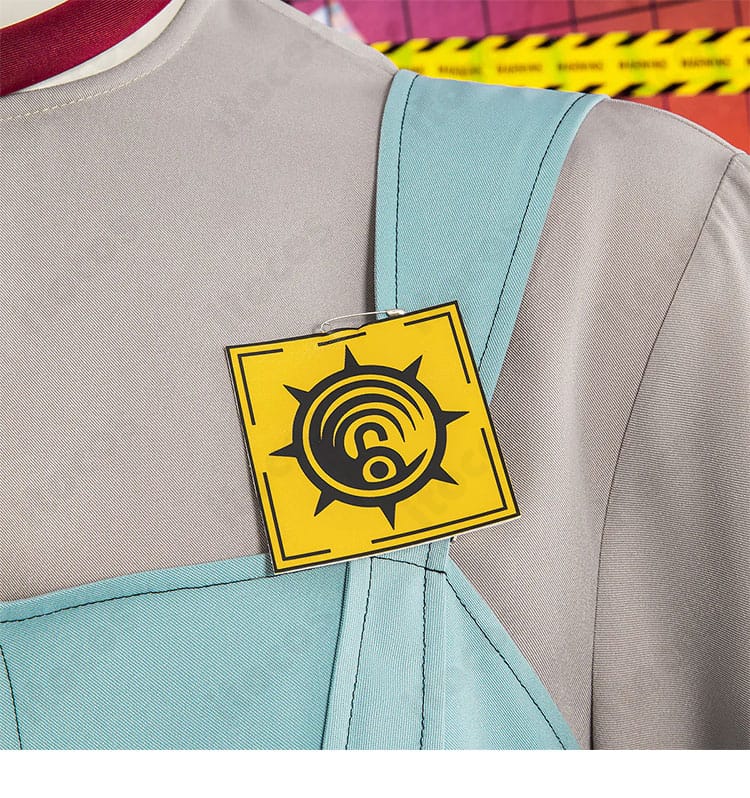 サロペット肩ベルトの徽章・ストラップ装飾。存在感のあるアクセントパーツの質感が分かるアップ。