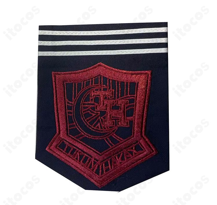 胸元エンブレム装飾の拡大。位置と意匠を確認でき、作品イメージに沿った上品な仕上がりを示すカット。