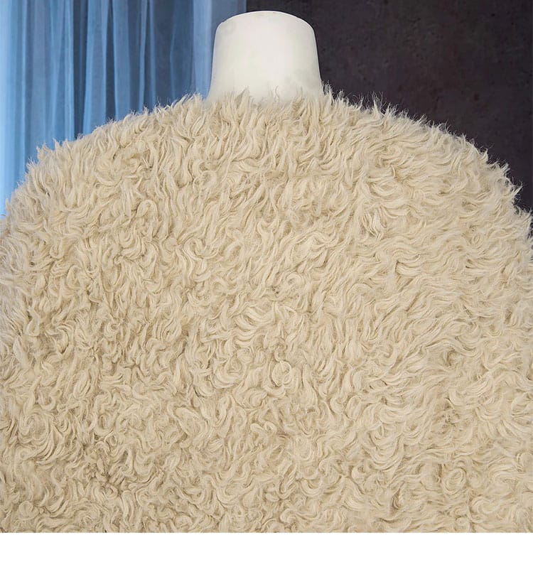 マント装飾ディテール。生地の落ち感と縁取りの仕上げを示す近接画像